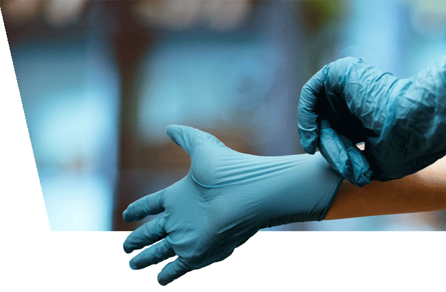 A medical professional trying on disposable examination gloves